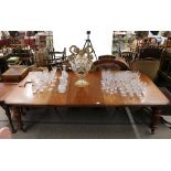 A Victorian mahogany extending dining table, raised on turned baluster supports terminating in brass