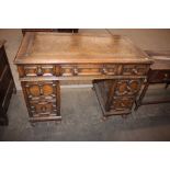 A good quality reproduction oak pedestal writing desk, fitted seven geometric moulded panel