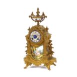 A 19th Century gilded and porcelain panel French mantel clock, surmounted by an urn finial above