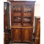 A 19th Century mahogany bookcase, the upper section enclosed by a pair of glazed arched panelled