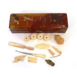 An Oriental lacquered glove box and contents of various ivory and bone sewing items, mother of pearl