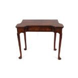 An 18th Century walnut card table, the shaped foldover top baize lined with sunken counter wells,