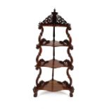 A Victorian rose wood graduated corner whatnot, having pierced and carved foliate decoration