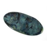 A Ruskin pottery high fired tablet, of ovoid shape, glazed in swirling greens and blues, impressed