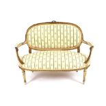 A 19th Century gilt and cream decorated twin seat salon settee, having foliate decoration, striped