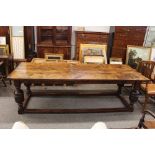 A antique oak refectory table, raised on baluster cup and cover supports united by stretchers,