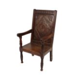 An Antique oak Wainscot chair, with lozenge and roundel carved panel back, scrolled arms above solid
