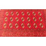 An Afghan red pattern rug, 181cm x 128cm