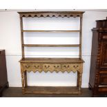 An Antique oak and pine dresser, of shallow proportions, having open plate rack above three drawers,