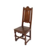 An Antique oak hall chair, with panel back above solid seat, raised on block turned supports