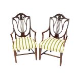 A pair of 19th Century carved mahogany elbow chairs, having shaped and pierced lyre backs,