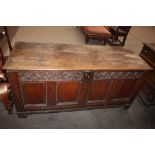 A 17th Century oak coffer, the plank top above a foliate carved frieze, inset with initials "HM"