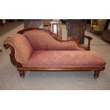 A Victorian carved mahogany chaise longue, the scrolled back with acanthus decoration, raised on