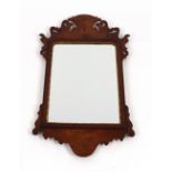 A walnut Chippendale style fret carved wall mirror, with gilt foliate surround, 77cm x 52cm