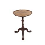 A mahogany wine table, having pie crust border top, raised on a turned baluster column and foliate