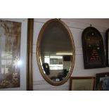 A gilt framed bevel edge oval wall mirror
