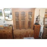 A pine bookcase raised on cupboard base fitted th