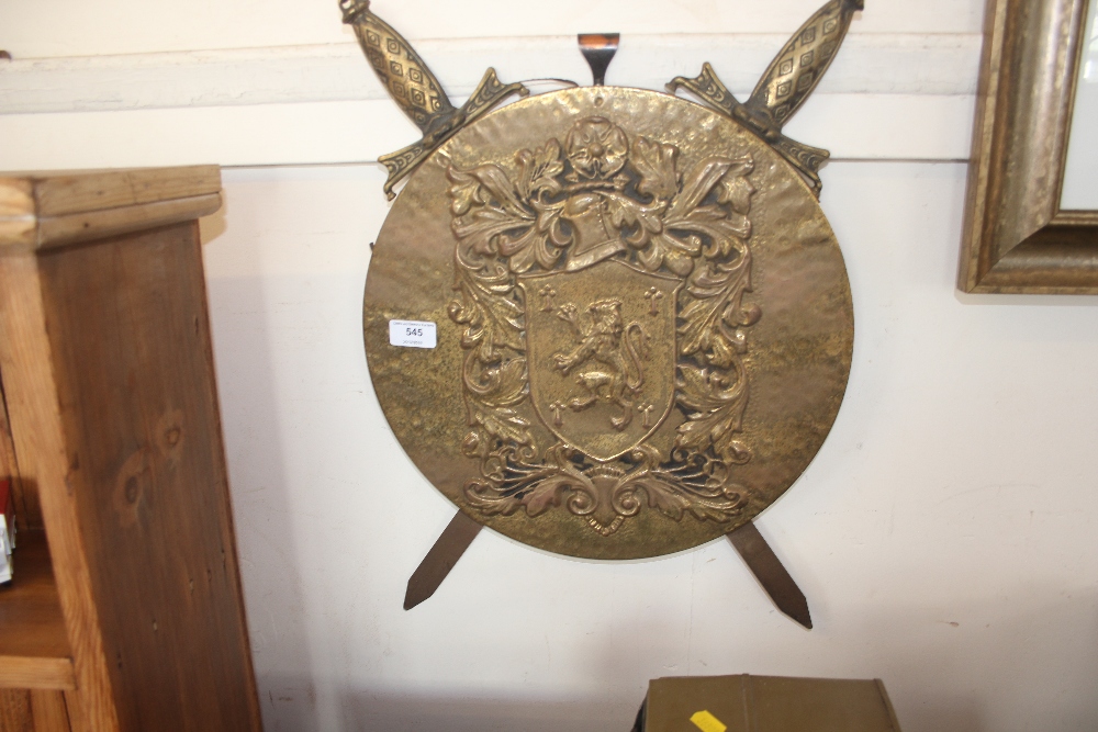 A brass embossed wall plaque decorated with crosse