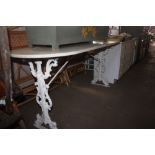 A white painted ornate cast iron based table with