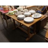 A Heal's type light oak refectory style kitchen table, the chamfered top raised on double column end