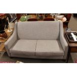 A modern design grey three seater sofa, raised on square section supports