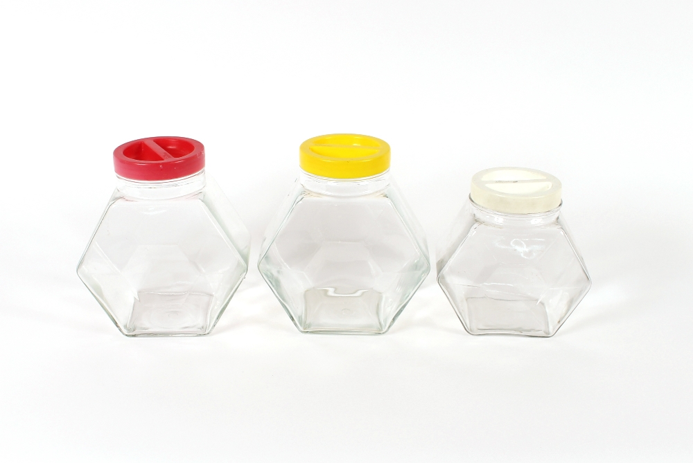 Three Italian Art Deco style glass storage jars, with plastic screw tops