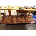 A retro metal framed two tier coffee table, the top decorated with Romanesque scenes, 114cm