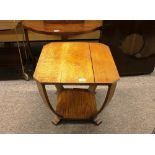 An Art Deco oak two tier occasional table, the canted corner top raised on bowed supports, 49cm