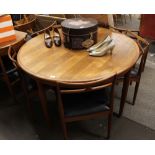 A circular teak extending dining table, in the G plan style and six matching chairs