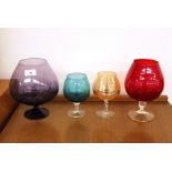 Four coloured glass brandy balloons, of various si