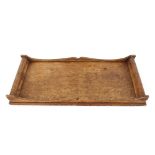 An Arts & Crafts oak wine tray, decorated with Glasgow roses, signed with initials FCP, 52cm long