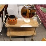 A retro formica and gilded metal two tier tea trolley, raised on rubber tyre castors