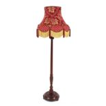 A mahogany turned column standard lamp, with floral tasselled shade