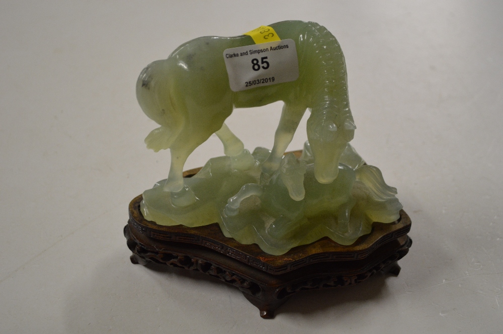 A modern jade horse and foal ornament on hardwood