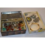 A tin and a tray of various costume brooches, ear-