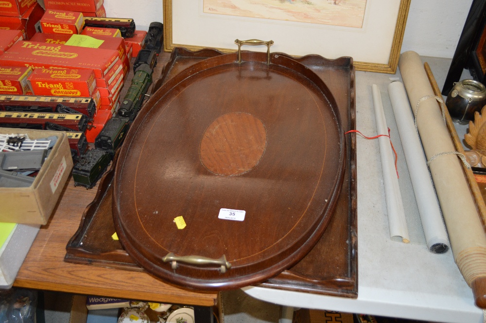 An Edwardian mahogany and inlaid oval tray; and on