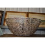 A large metal pierced bowl