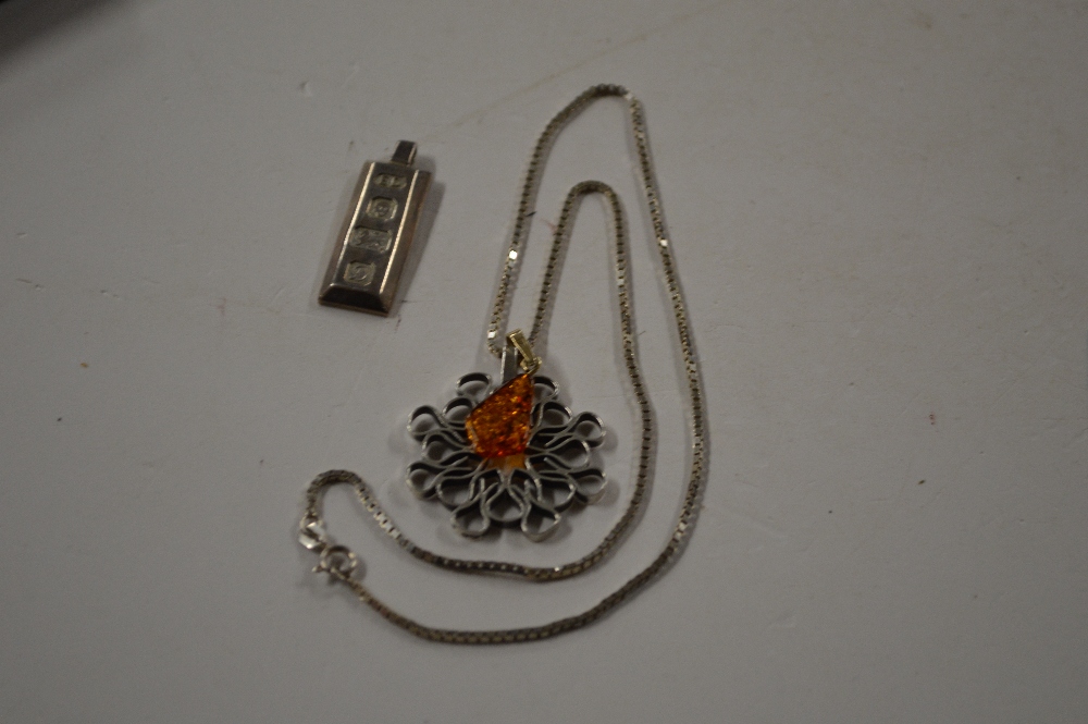 A silver and amber pendant hung to a fine link cha