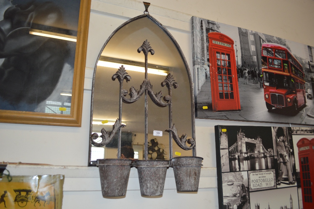 A metal framed mirror with three hanging pots