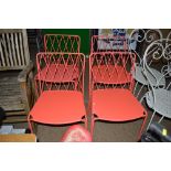 A set of four red painted metal chairs