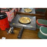 A brass ashtray together with a wooden bread board