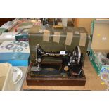 A Singer hand sewing machine in fitted case