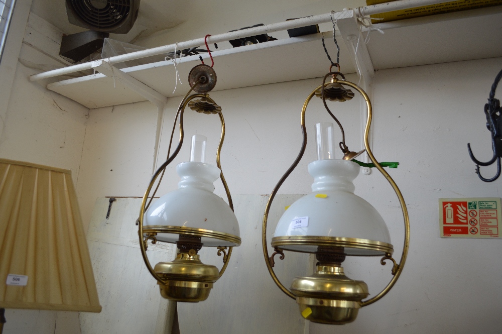 Two brass hanging oil lamps with milk glass shades