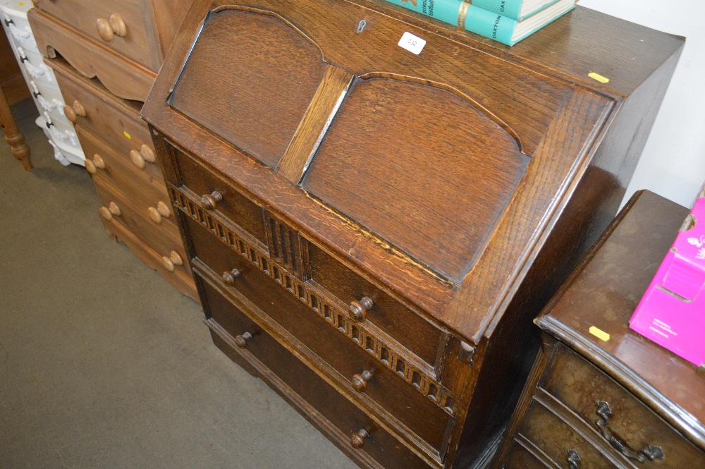 An oak bureau fitted three long drawers