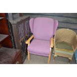 A purple upholstered wing back arm chair