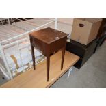 A small mahogany sewing cabinet on tapered legs