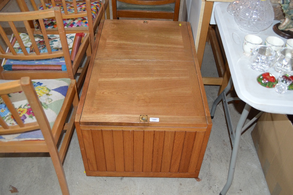 An oak storage box with sliding top and panelled s
