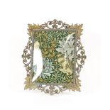 An ornate brass frame, with William Morris type material panel, 42cm x 31cm overall