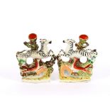 A pair of 19th Century Staffordshire spill holders, in the form of running Zebras and hounds, 20cm
