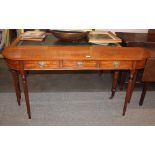 A satinwood bow fronted hall table, fitted three drawers, raised on turned tapering fluted supports,